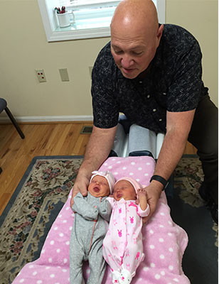 Infant twins getting adjusted by Dr Braile a chiropractor in Marietta GA